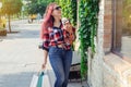 Fashionably dressed girl at the window of a boutique selling clothes. A woman holds a mini chihuahua in her arms. The pet is Royalty Free Stock Photo