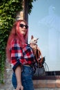 Fashionably dressed girl at the window of a boutique selling clothes. A woman holds a mini chihuahua in her arms. The pet is Royalty Free Stock Photo