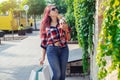 Fashionably dressed girl at the window of a boutique selling clothes. A woman holds a mini chihuahua in her arms. The pet is Royalty Free Stock Photo