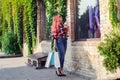 Fashionably dressed girl at the window of a boutique selling clothes. A woman holds a mini chihuahua in her arms. The pet is Royalty Free Stock Photo