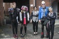 Fashionably-dressed group of young people standing near the wall. Royalty Free Stock Photo