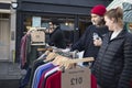 Fashionably dressed man and woman choose second hand vintage clothing at local Broadway market on a Saturday