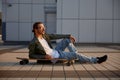 Fashioned hipster guy rest with skateboard sitting in asphalt street road Royalty Free Stock Photo