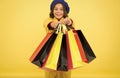 Fashionista adore shopping. Obsessed with shopping. Girl cute kid hold shopping bags on yellow background. Mid season