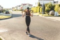 Fashionly dressed skater girl posing with board on the city road. Sunset time. Royalty Free Stock Photo