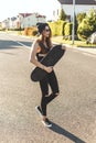 Fashionly dressed skater girl posing with board on the city road. Sunset time. Royalty Free Stock Photo