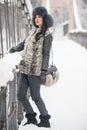 Attractive woman with black fur cap and gray waistcoat enjoying the winter. Side view of fashionable brunette girl posing Royalty Free Stock Photo