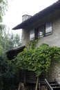 Fassade of an old farm house in trento with wodden stairs. On the old roof grows a kiwi fruit. Royalty Free Stock Photo