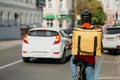 Fast bicycle courier. Delivery man in safety helmet, with bag rides a bicycle