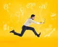 Fast business concept with businessman running with a laptop. Yellow background Royalty Free Stock Photo