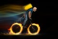 Fast delivery service - deliveryman on bicycle driving with order in fire on dark background