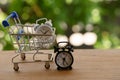 Fast delivery, time value of money concept : white analog clock in a blue - silver shopping cart or a supermarket shopping basket