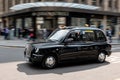 Fast driving classical black retro LTI TX4 taxi cab in the streets of Glasgow with a strong motion blur effect emphasizing the