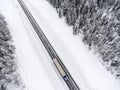 Fast driving semitrailer truck is on slippery winter asphalt highway, top view from drone