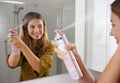 Fast and easy way to covering grey hair with instant spray dye. Young woman applying dry shampoo on her hair before going out Royalty Free Stock Photo