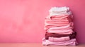 Fast fashion, Overconsumption, trends in fashion industry. Stack of pink clothing on pink background. Pile of trendy pink shirts, Royalty Free Stock Photo