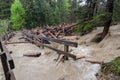 Fast flooding and logs and debris against pedestrian bridge