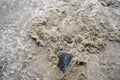 Flowing muddied water around the rock Royalty Free Stock Photo
