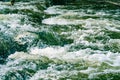 Fast flowing stream mountain river, emerald-colored water, strong current on rocky rapids Royalty Free Stock Photo