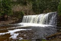 The fast flowing Waiau Waterfall located in the forest of New Zealand. The water flows over a rocky cliff into a deep Royalty Free Stock Photo