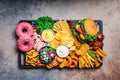 Fast food platter. Junk food concept. Unhealthy food for the heart, teeth, skin, figure, top view