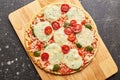 Fast food baked frozen pizza with cheese, tomatoes and pesto. Ready to eat. Royalty Free Stock Photo