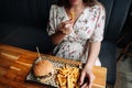 Fast food burger eat pregnant girl. Pretty young happy pregnancy woman eating tasty hamburger. Junk food concept. Royalty Free Stock Photo