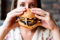 Fast food burger eat. Pretty Young Happy Woman Eating Tasty Hamburger. Junk Food Concept. Royalty Free Stock Photo