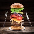 Fast food concept - flying hamburgers ingredients on a wooden background