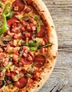 Fast food concept. Half pizza top view with crunchy dough and fresh ingredients on wood Royalty Free Stock Photo