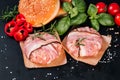 Fast food. Convenience food, fast home cooking.Two chicken hamburgers wrapped in bacon on cave paper with basil leaves, red