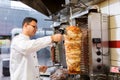 Chef slicing doner meat from spit at kebab shop Royalty Free Stock Photo