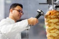 Chef slicing doner meat from spit at kebab shop Royalty Free Stock Photo