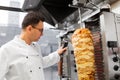 Chef slicing doner meat from spit at kebab shop Royalty Free Stock Photo