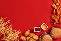 Fast food dish top view. Meat burger, potato chips and nuggets on red background. Takeaway composition.