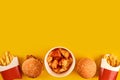 Fast food dish on yellow background. Fast food set fried chicken, meat burger and french fries. Take away fast food. Royalty Free Stock Photo