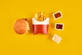 Fast food dish on yellow background. Fast food set meat burger, three sauce and french fries. Take away fast food. Royalty Free Stock Photo