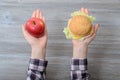 Fast food healthy unhealthy lifestyle eating decision diet fruit slimming weight loss concept. Close up photo of hands with apple Royalty Free Stock Photo