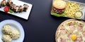Fast food, junk food concept. Copy space banner, flat lay, top view. Pizza, burger with fries, dumplings, sushi set. Royalty Free Stock Photo