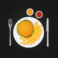 Burger and fries on a plate with fork and knife. Royalty Free Stock Photo