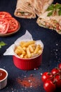 Fast food. Red bowl of french fries chips potato and sauces, doners on black background Royalty Free Stock Photo