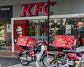 Fast food restaurant KFC view from the street, motorbike delivery service with cases refrigerators parked at entrance.