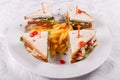 Fast food restaurant menu. Club sandwich with cheese, pIckled cucmber, tomato and smoked meat. Garnished with golden Royalty Free Stock Photo