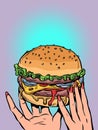 A fast food restaurant offering a burger. Delivery of delicious and hot food at your fingertips. Womans hands holding a