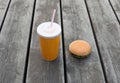 Fast food, unhealthy diet concept - juice cup and burger on wooden table or floor background Royalty Free Stock Photo