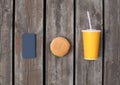 Fast food, unhealthy diet concept - phone with juice cup and burger on wooden table or floor background Royalty Free Stock Photo