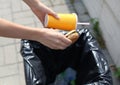 Fast food and unhealthy eating concept - hand throwing a burger with a plastic cup in garbage can Royalty Free Stock Photo