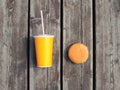 Fast food and unhealthy eating concept - juice cup with hamburger on a wooden table background Royalty Free Stock Photo