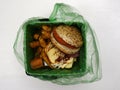 Fast food waste in a biodegradable garbage bag on a white
