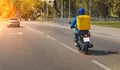 Fast and free food delivery carrying yellow box on a scooter during the day in the city Royalty Free Stock Photo